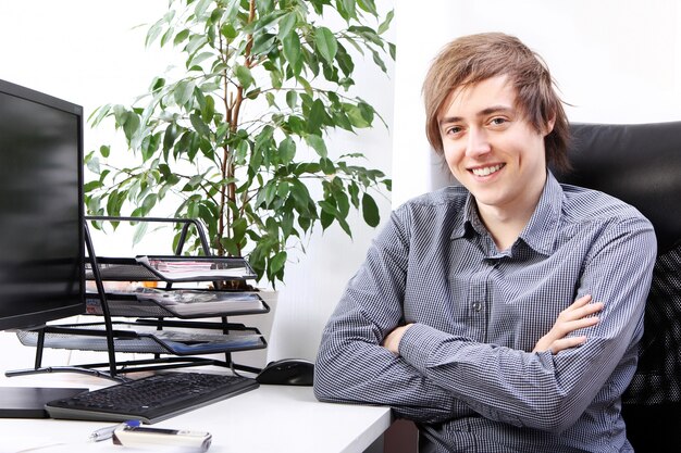 Jeune homme souriant au bureau