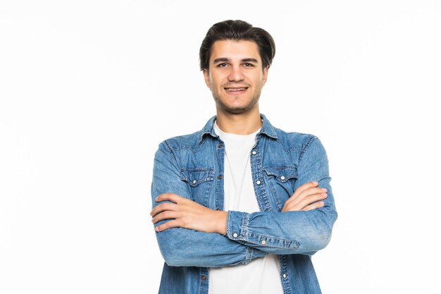 Jeune homme souriant avec les bras croisés sur blanc