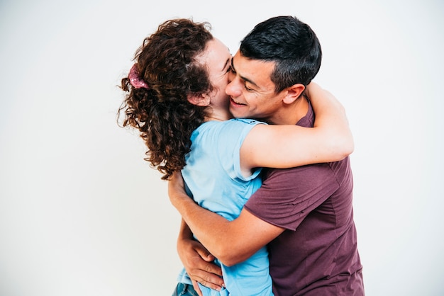 Jeune homme souriant, embrassant une femme