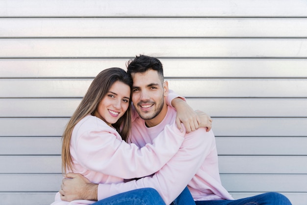 Jeune homme souriant embrassant avec jolie femme heureuse