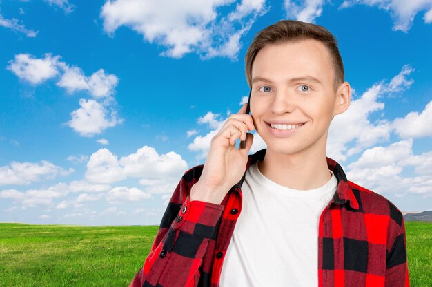 Jeune homme souriant, parler au téléphone mobile