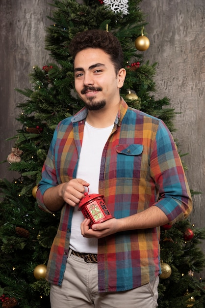 Jeune homme souriant tenant un jouet de Noël.