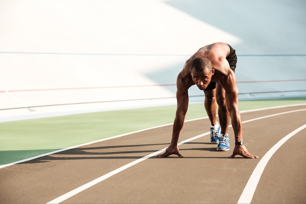 Photo gratuite jeune homme sportif africain en position de départ prêt à démarrer