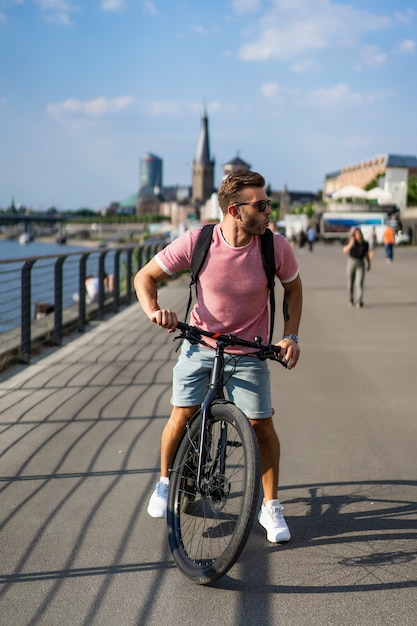 Jeune homme sportif à vélo dans une ville européenne. Sports en milieu urbain.