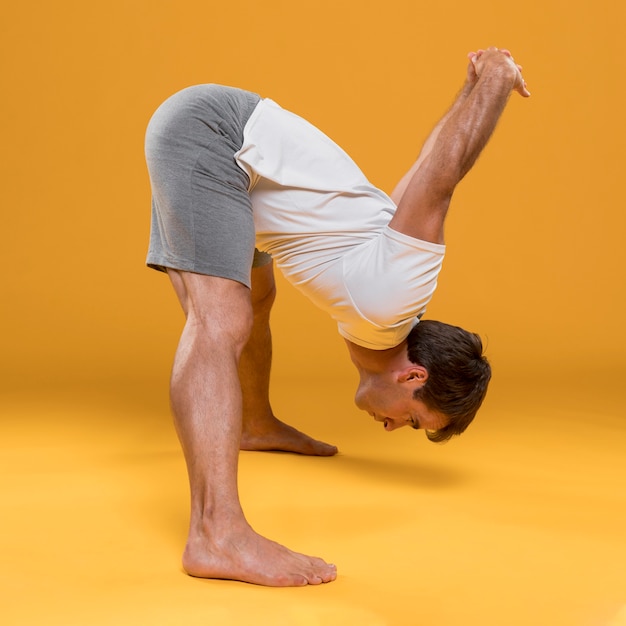 Photo gratuite jeune homme, stretching, dans, pose yoga