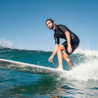 Jeune homme surfe sur les vagues de l'océan