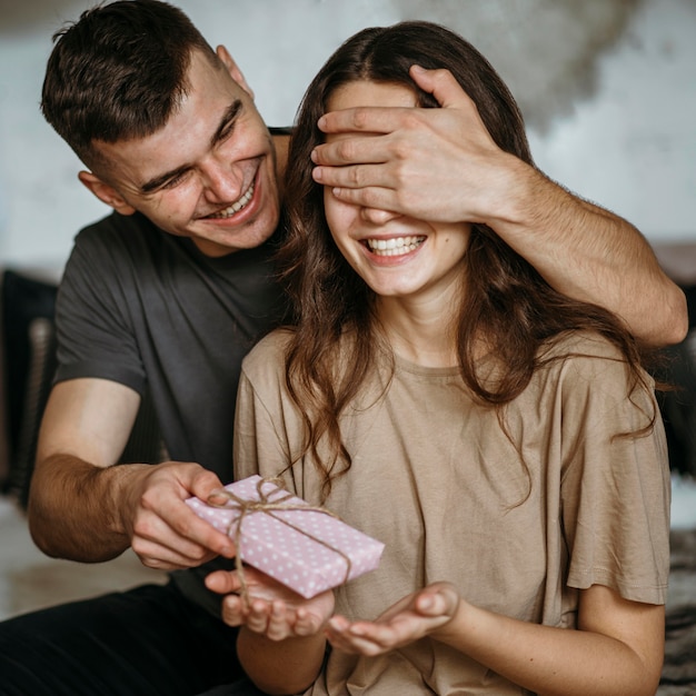 Photo gratuite jeune homme surprenante petite amie avec cadeau