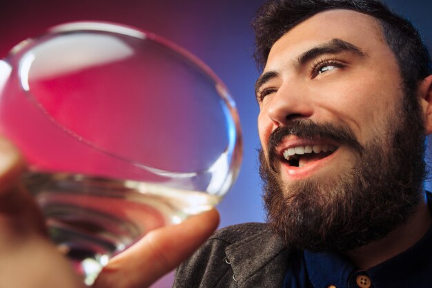 Le jeune homme surpris posant avec un verre de vin.