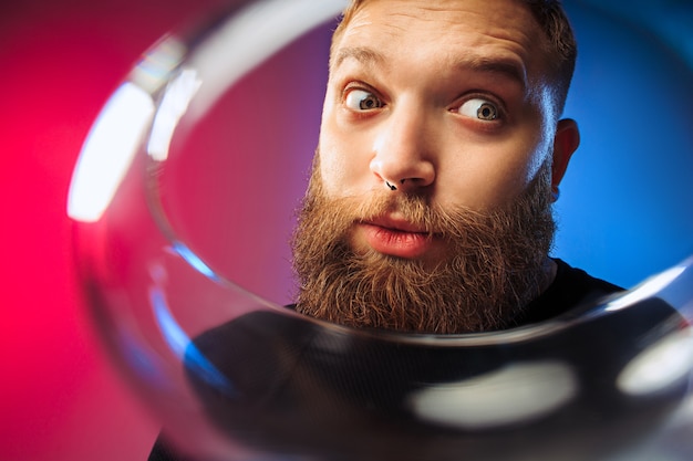 Le jeune homme surpris posant avec un verre de vin.