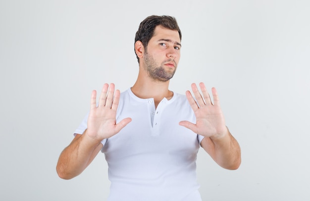 Jeune homme en t-shirt blanc ne montrant aucun signe et à la dégoût