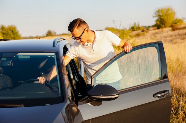 Jeune homme en t-shirt blanc tenant le volant