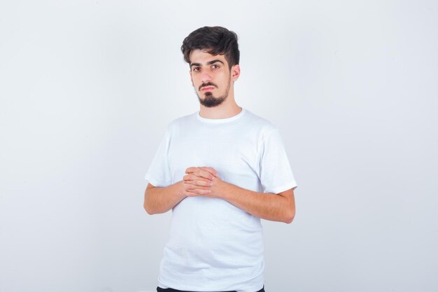 Jeune homme en t-shirt serrant les mains et à l'espoir