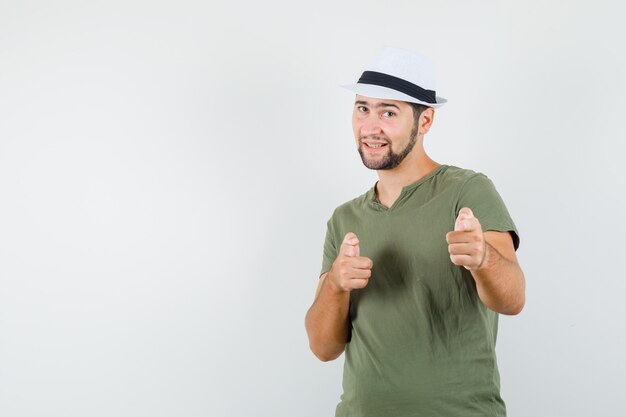 Jeune homme en t-shirt vert et chapeau pointant vers la caméra et à la confiance