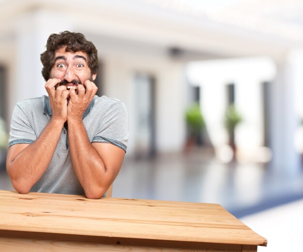 jeune homme sur une table. expression inquiète