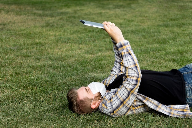 Photo gratuite jeune homme tablette de navigation à l'extérieur