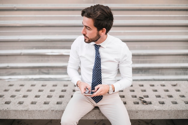 Jeune homme, à, téléphone portable, regarder loin