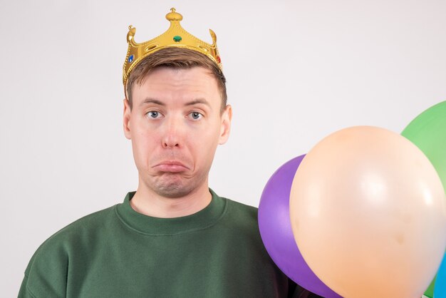 jeune homme tenant des ballons colorés sur blanc