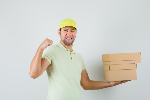 Jeune homme tenant des boîtes en carton en casquette de t-shirt et à la béatitude