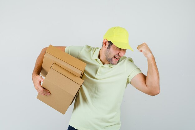 Jeune homme tenant des boîtes en carton en casquette de t-shirt et à la chance