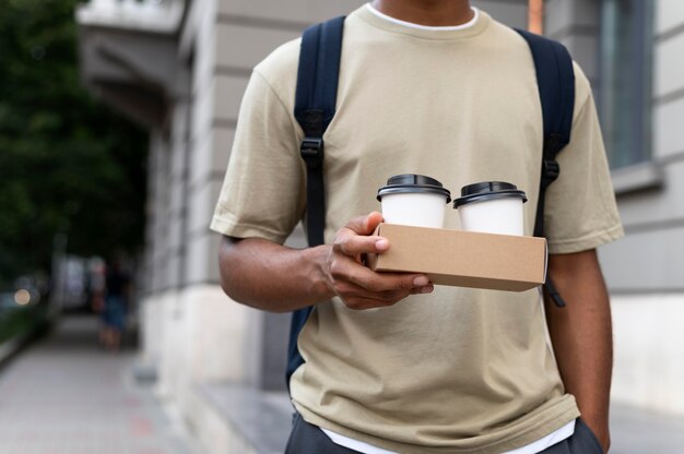 Jeune homme tenant un café à emporter