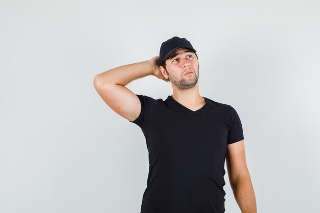 Jeune homme tenant la main derrière la tête en t-shirt noir