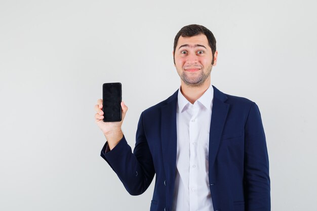 Jeune homme tenant un téléphone mobile en chemise