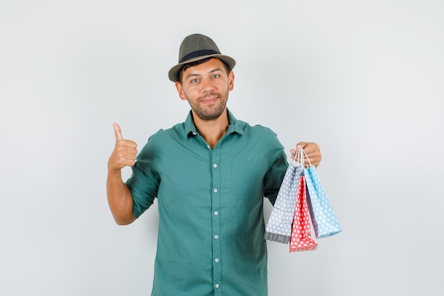 Jeune homme, tenue, sacs papier, à, pouce haut, dans, chemise