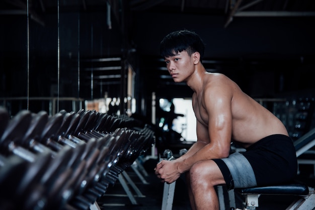 Jeune homme en tenue de sport une classe d&#39;exercices dans une salle de sport