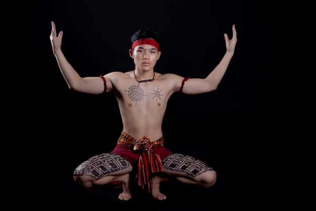 jeune homme thaïlandais faisant une danse traditionnelle