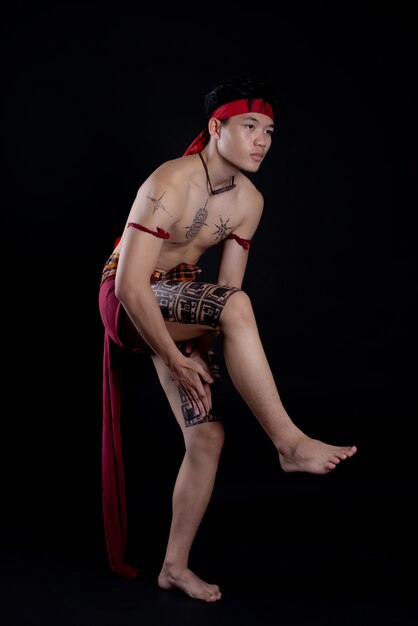 jeune homme thaïlandais faisant une danse traditionnelle