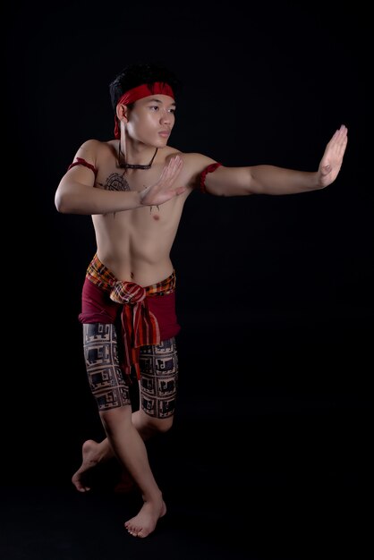 jeune homme thaïlandais faisant une danse traditionnelle