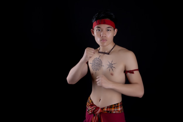 jeune homme thaïlandais faisant une danse traditionnelle