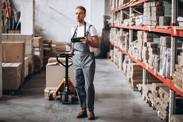 Jeune homme travaillant dans un entrepôt avec des boîtes