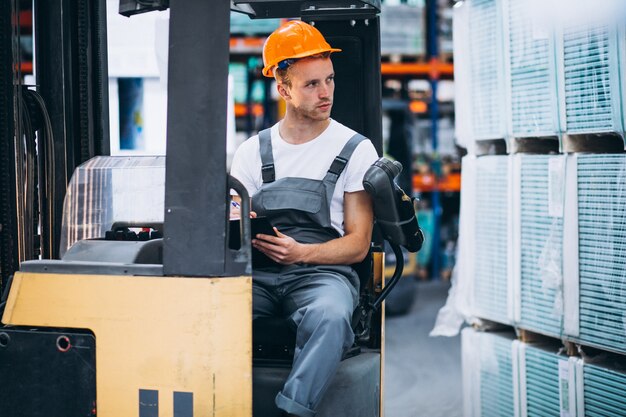 Jeune homme travaillant dans un entrepôt avec des boîtes