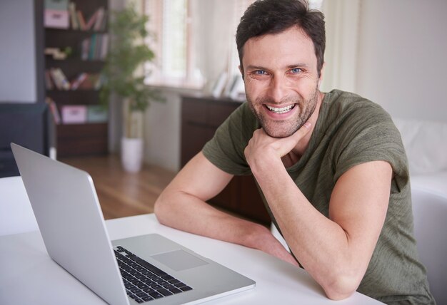 Jeune homme travaillant à la maison avec son ordinateur portable