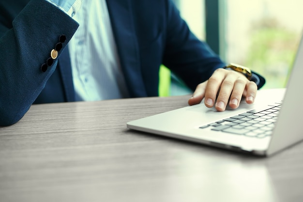 Jeune homme travaillant avec un ordinateur portable, les mains de l'homme sur un ordinateur portable, homme d'affaires au lieu de travail