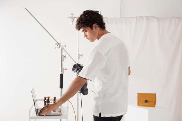 Un jeune homme travaille dans son studio de photographie.
