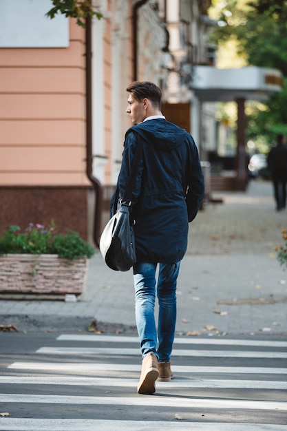 Photo gratuite jeune homme traverser la rue