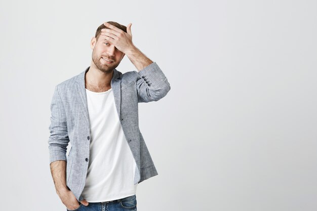 Jeune homme troublé facepalm et l'air dérangé