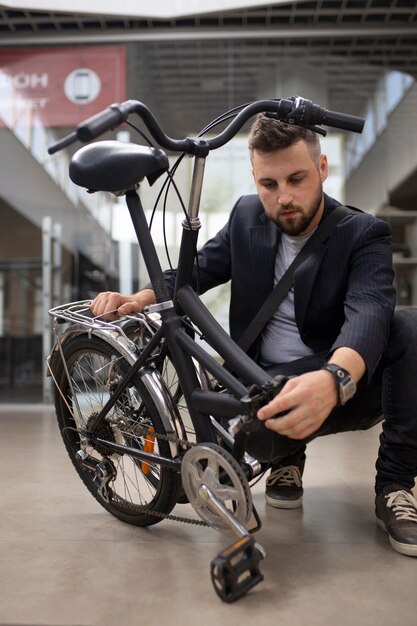 Jeune homme utilisant un vélo pliant dans la ville