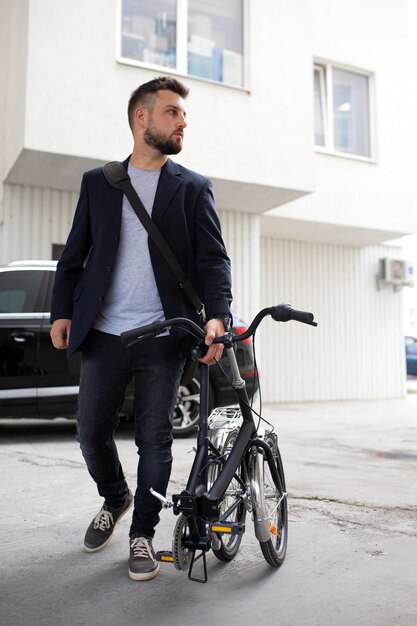 Jeune homme utilisant un vélo pliant dans la ville
