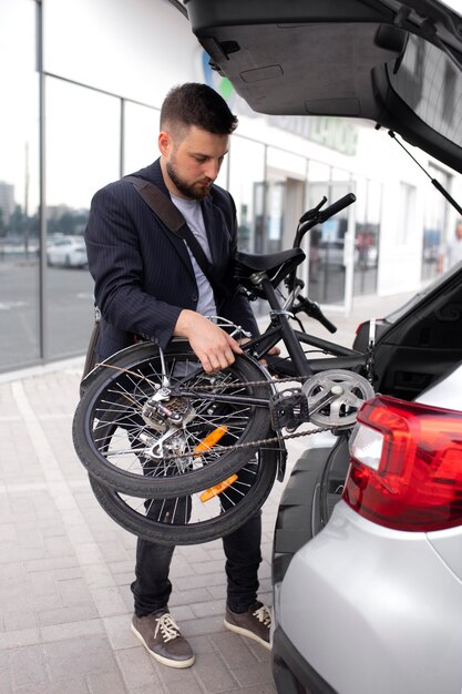 Jeune homme utilisant un vélo pliant dans la ville