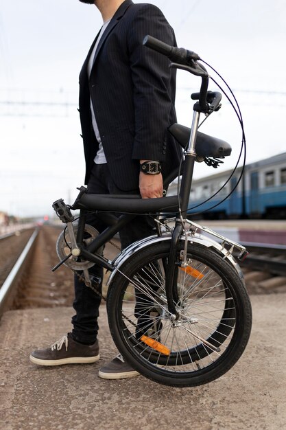 Jeune homme utilisant un vélo pliant dans la ville