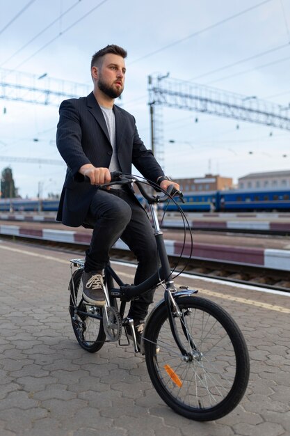 Jeune homme utilisant un vélo pliant dans la ville