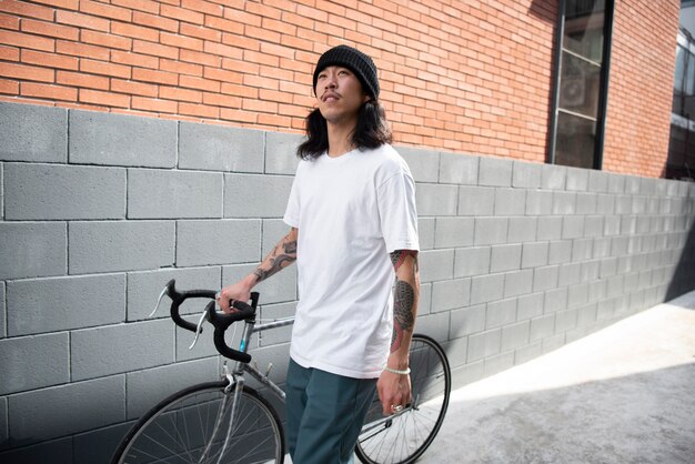 Jeune homme avec un vélo dans la ville