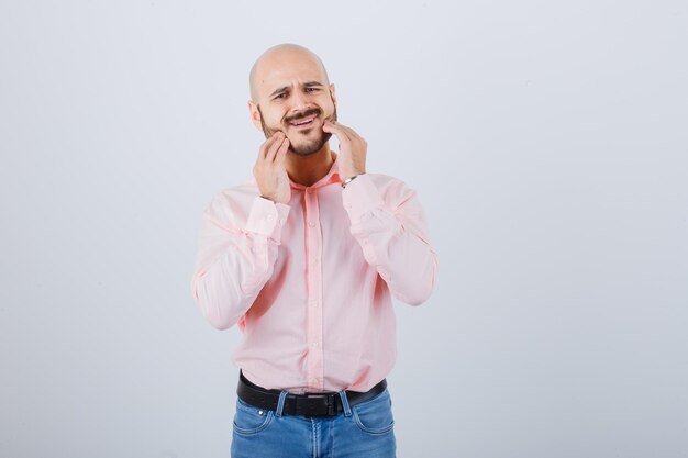 Jeune homme vérifiant la peau en touchant sa barbe