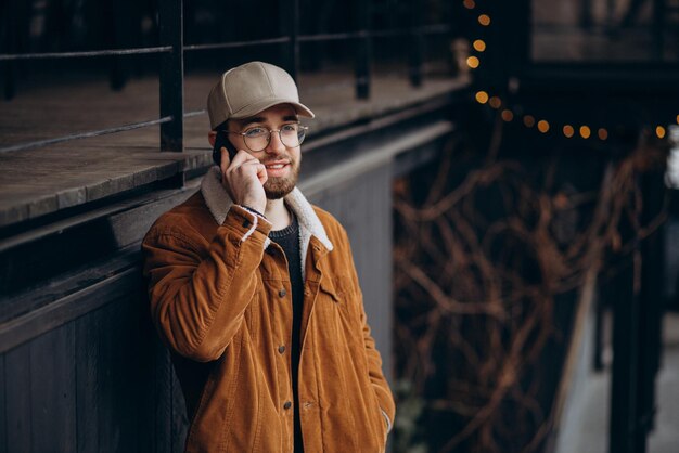 Jeune homme en veste à l'aide de téléphone