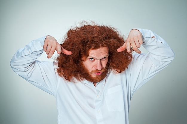 jeune homme vexé aux longs cheveux roux