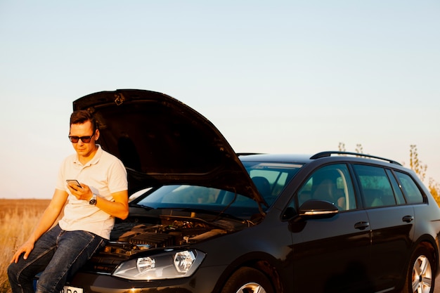 Photo gratuite jeune homme et voiture avec le capot ouvert