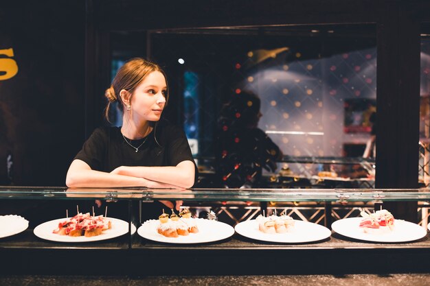 Jeune hôtesse près de tartines